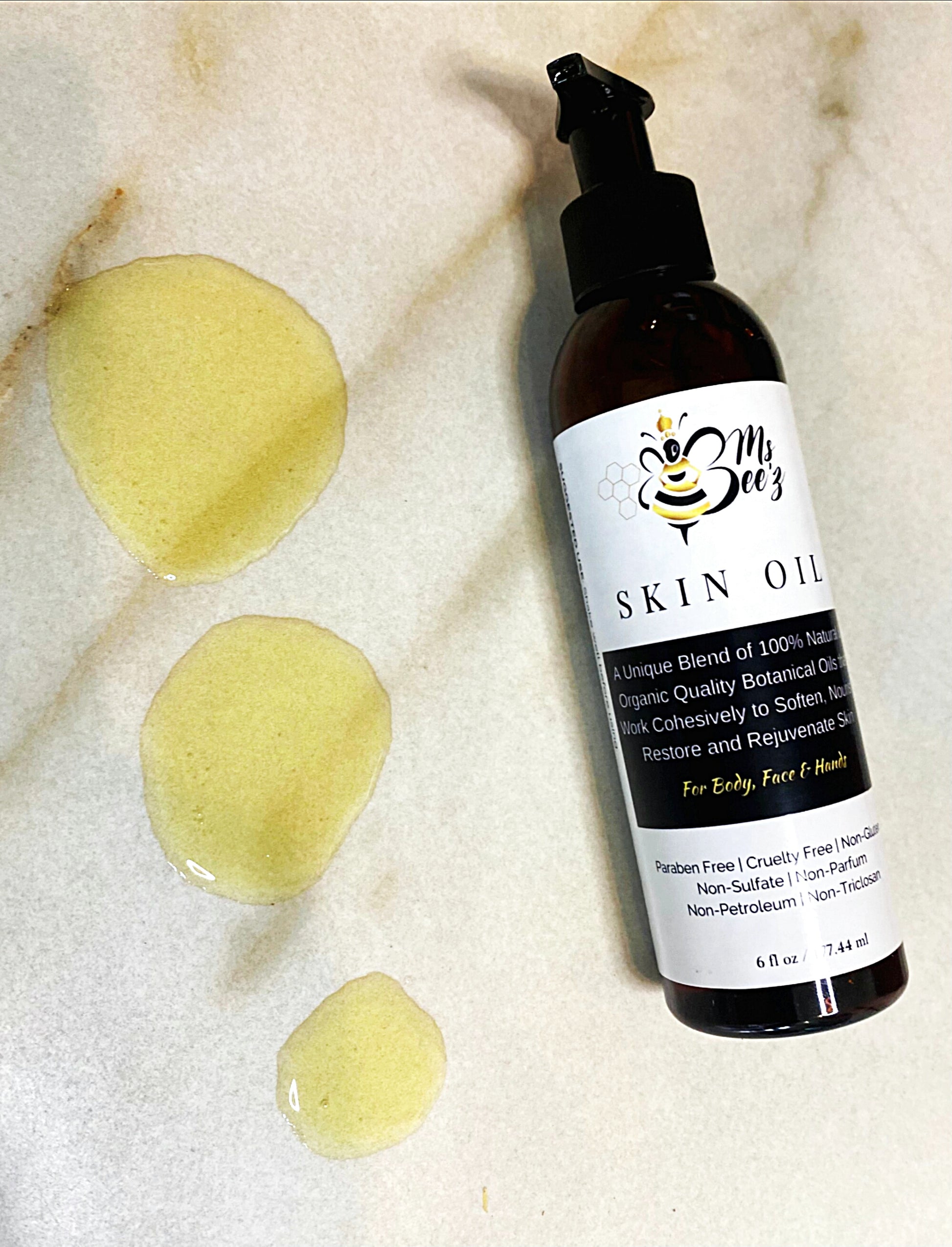 ms beez beauty skin oil laying on marble counter with drop of skin oil